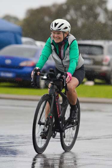 women cyclist smiling in pouring rain